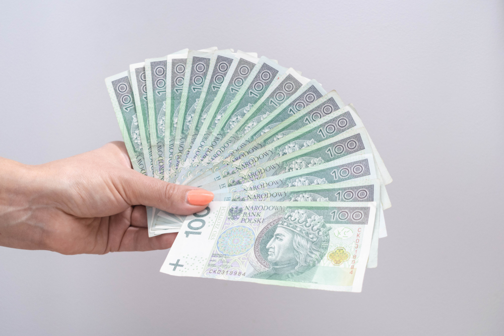 Dłoń trzymająca plik banknotów rozłożony jak wachlarz 